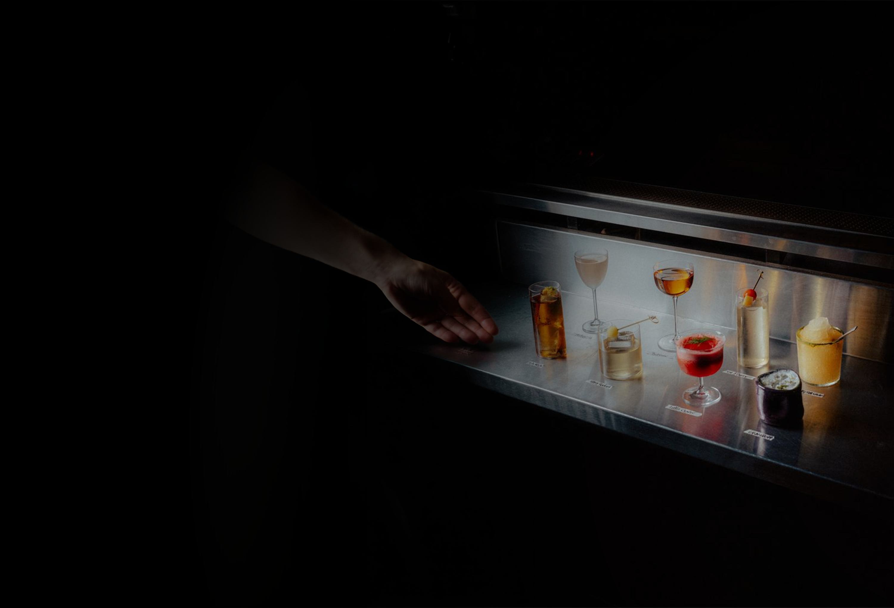 A row of cocktails on a lit bar